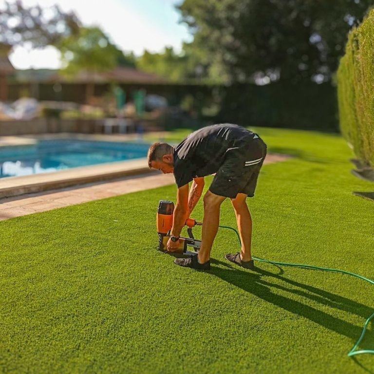 Instalador aplicando el Sistema ECOS de grapado en una unión de césped artificial